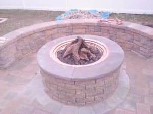 36" stone fire pit with seating wall by Custom Quality Renovations.
