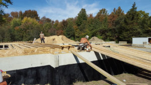 licensed Custom Quality Renovations contractors laying subfloor.