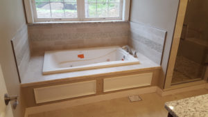 Bathtub with custom tile by Custom Quality Renovations.